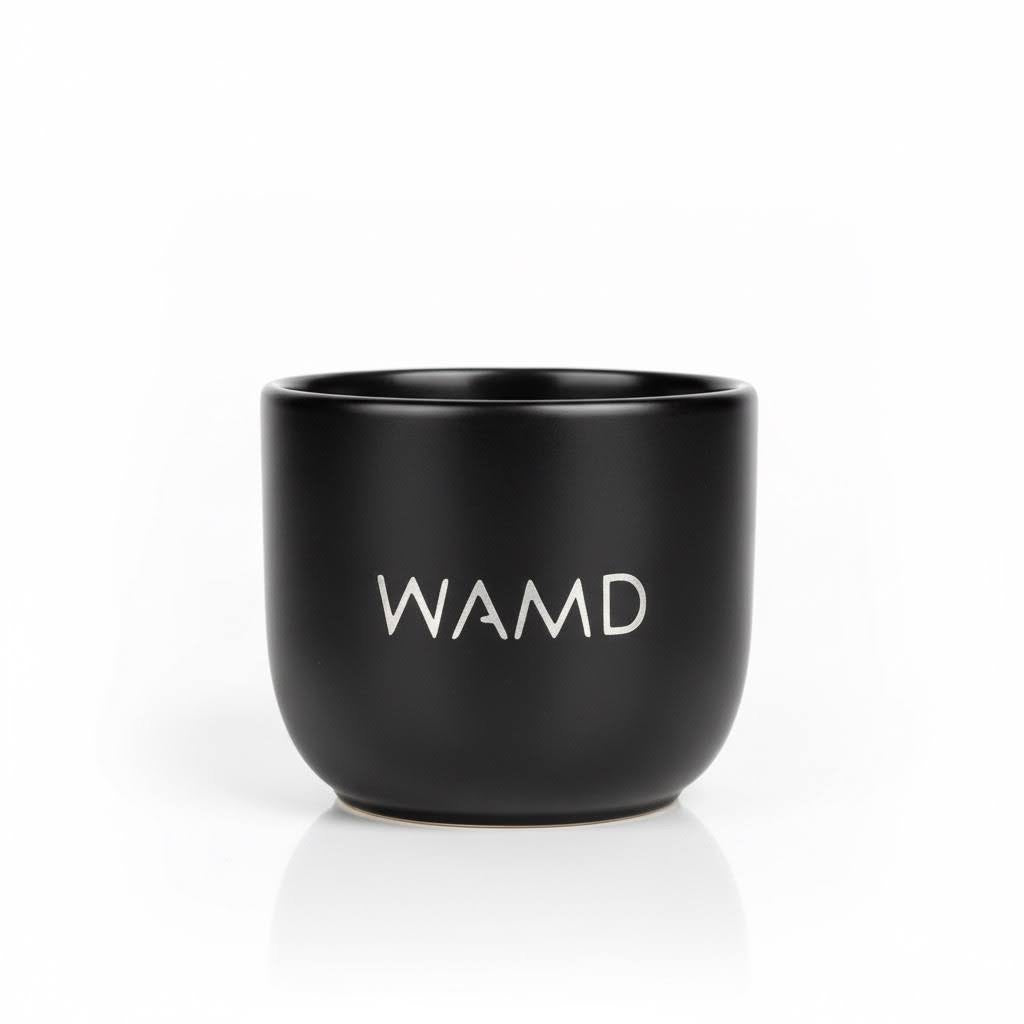Black mug with 'WAMD' branding on a white background